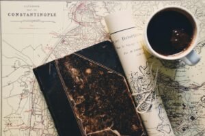 Image d'une carte du monde, d'un carnet de note et d'une tasse de café : équipement du travel planner
