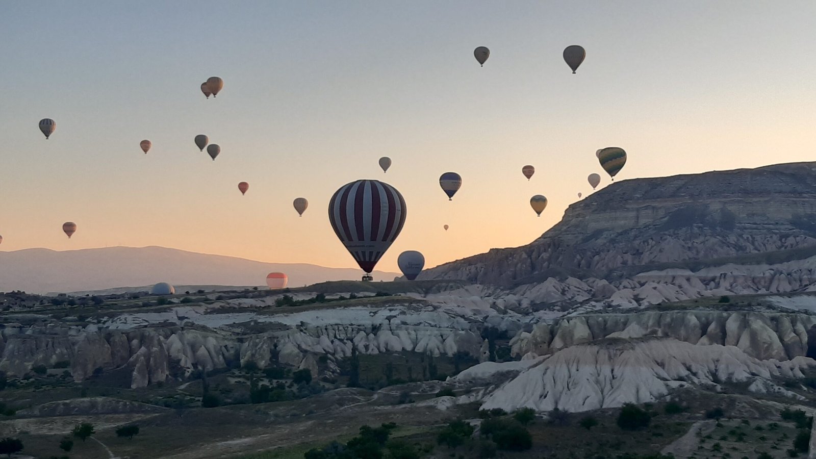 Vue sur des montgolfières en Cappadoce au lever du soleil. Organisation d'un voyage en Turquie